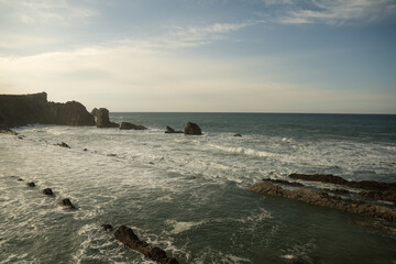 Olas rompiendo en la costa con rocas y horizonte despejado