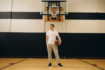 The basketball player poses calmly in front of the camera, as if thinking about his next shot, with...
