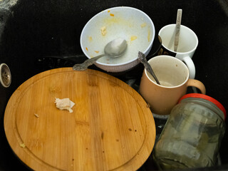 A Sink Full of Dirty Dishes and Utensils Awaiting Thorough Cleaning and Organization