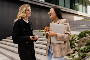 young pretty women walking talking in street doing business