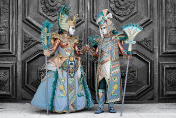 Venetian Carnival Masked Couple in Egyptian-Inspired Costumes on Gray Background
