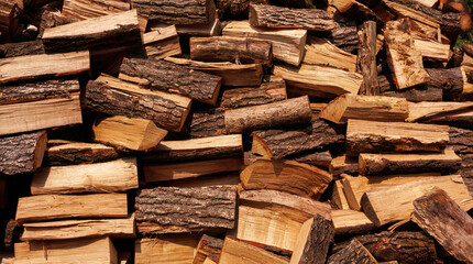 Stack of freshly chopped firewood with bark
