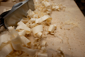 Wood plane with wood shavings on a workbench
