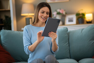  Beautiful woman using digital tablet at home