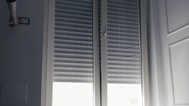 Smart Home Convenience Man Controls Roller Shutter with Wall Switch