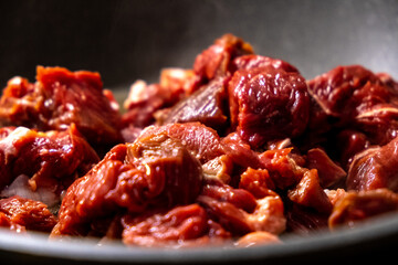 Sizzling Raw Meat Cuts Cooking in a Dark Pan, Ready to Be Barbecued and Eaten Soon