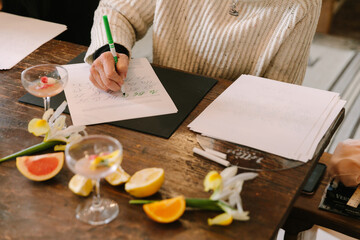 Participants engage in a creative lettering workshop at a cozy studio with refreshing beverages and floral decor