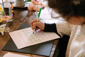 Creative calligraphy workshop in a cozy indoor setting with participants enjoying drinks and...