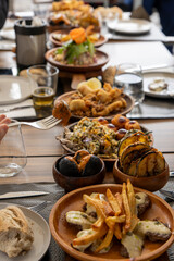 A selection of various Canarian dishes served on a wooden board in a restaurant in La Palma, Spain.