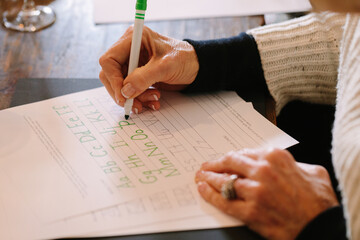 Practicing calligraphy with worksheets at a creative workshop in a cozy indoor setting