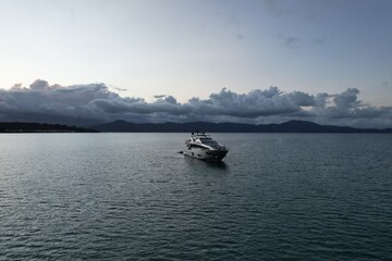 Elegant yacht anchored in calm waters at twilight by the mountains