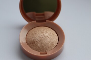 Beige pearlescent eyeshadow in an open case with a mirror