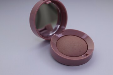 Beige pearlescent eyeshadow in an open case with a mirror