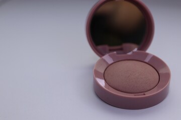 Beige pearlescent eyeshadow in an open case with a mirror