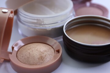 Set of decorative cosmetics and makeup brushes on a white background, eye shadow, blush, powder, bronzer, makeup brushes