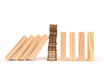 Stack of coins stopping wooden blocks from falling and protecting the other row of wooden blocks on...
