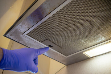 Replacing the filter mesh in the kitchen hood.Removing dirt in the kitchen.