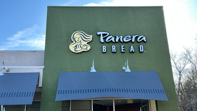 NORWALK, CT, USA - MARCH 12, 2025: Panera Bread sign on facade with a bright green exterior and blue awning invites visitors under a sunny sky.