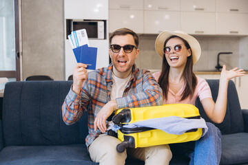 Couple holding passport and tickets showing excitement for upcoming trip