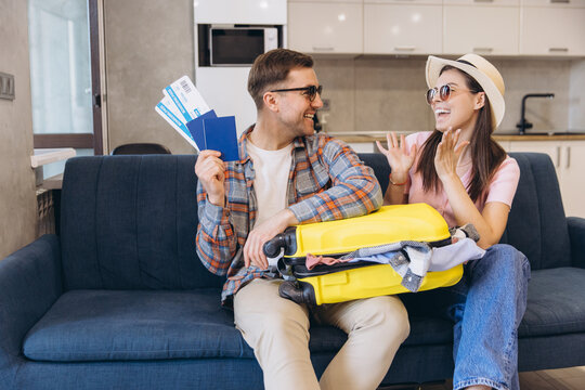 Happy couple planning vacation holding passport and airplane tickets
