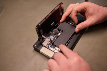 A disassembled smartphone showcasing its internal components along with the battery itself