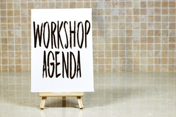 Workshop Agenda Displayed on Easel Against Tiled Background