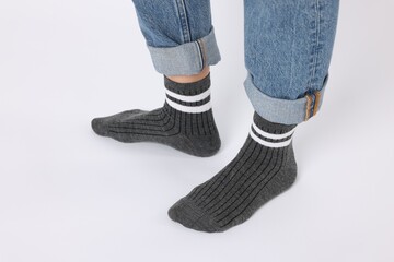 Woman wearing gray socks on white background, closeup