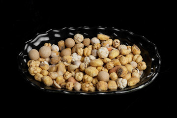 Nut Mix on a Plate Against a Black Background