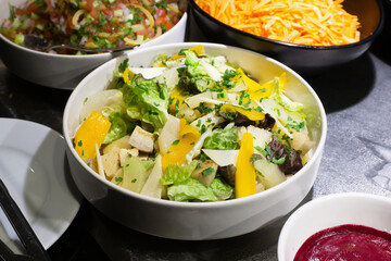 Delicious fresh salad with lettuce and mango background. Colorful and healthy dish with vibrant ingredients. Combining crisp greens and sweet tropical fruit for a refreshing meal.
