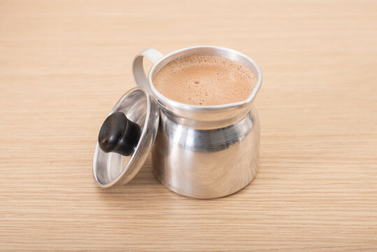 Jarra o chocolatera con chocolate caliente listo para tomar