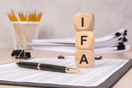Stacked wooden cubes with "IFA" letters, symbolizing financial advising, investment, and wealth management.