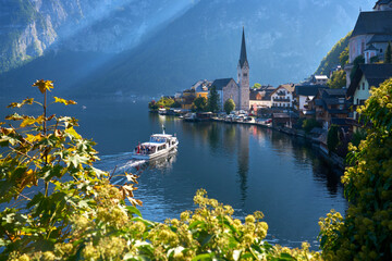 Hallstatt Village and Passenger Ferry. The passenger ferry arriving at the famous lakeside town of Hallstatt in the Austrian Alps, Salzkammergut region, Upper Austria, Europe.  © maxdigi