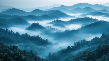 Fototapeta premium Misty mountain range at sunrise, blue hues, scenic landscape.