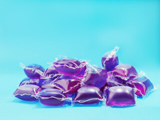 Pile of blue color laundry washing pods on blue color background. Cloths cleaning product. Chemical for easy home use in a washing machine.