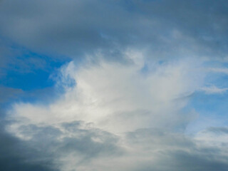 The sky is cloudy and the sun is not visible. The clouds are white and grey. The sky is blue and the clouds are scattered