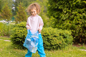 Girl collection plastic garbage in nature. kid picking up trash in park. Earth Day April 22. Save...