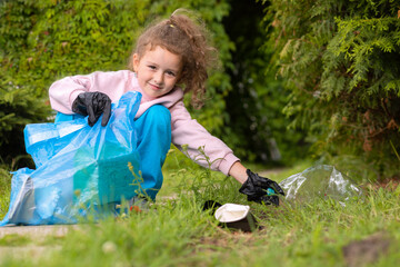 Girl collection plastic garbage in nature. kid picking up trash in park. Earth Day April 22. Save...
