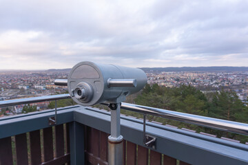 Scenic City Lookout – The silver observation binoculars take center stage as they frame a...