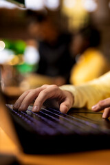 Scholar girl writing an essay on her laptop during homework session at the library, highlighting intense research and preparation for a class. Smart pupil finishes an assignment. Close up.