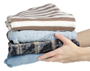 Hand holding stack of clothes jeans on white background isolation