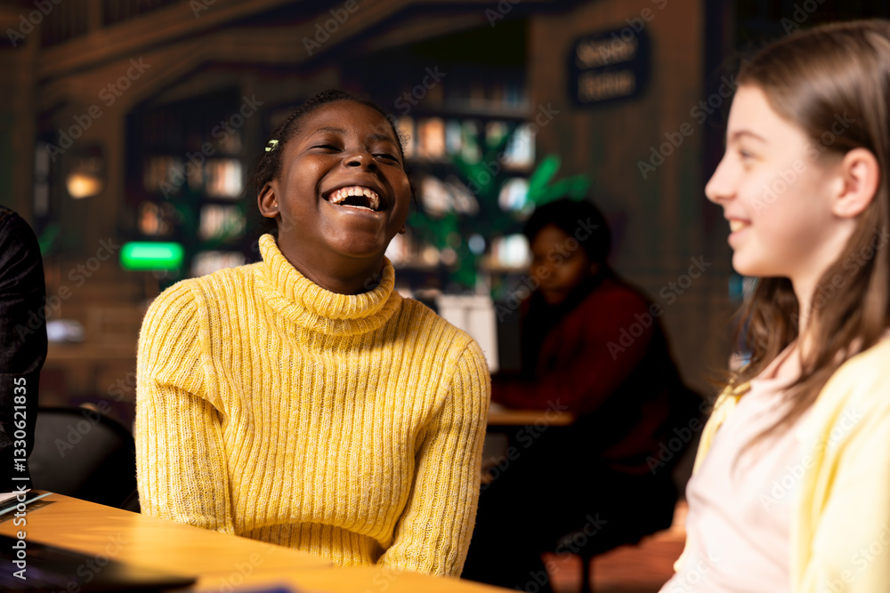 Poster adorable girlfriends gossiping and joking around in the school library, taking a break from class as