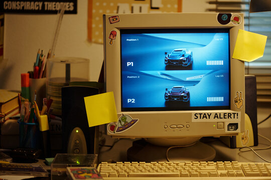 Vintage computer setup featuring gaming screen prominently, surrounded by office supplies and sticky notes scattered around monitor. Cozy workspace displaying nostalgic atmosphere