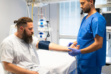 Obraz premium Nurse taking blood pressure of patient in hospital room