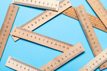 Wooden rulers on blue background