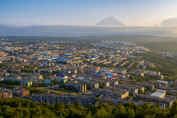 Morning cityscape. Top view of the buildings and streets of the city. Residential urban areas at sunrise. Koryaksky volcano in the distance. Petropavlovsk-Kamchatsky, Kamchatka Krai, Russian Far East.