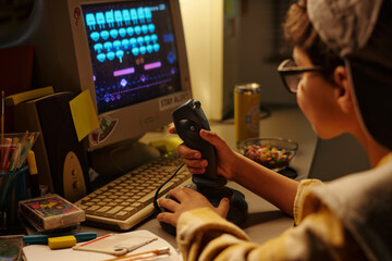 Child engrossed in playing retro video game on old computer, with variety of colorful items scattered on desk, creating an immersive gaming environment