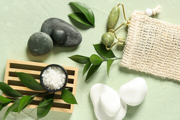 Obraz na płótnie Canvas Composition with facial massage tools, spa stones, sea salt and plant branches on color background