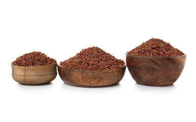 Wooden bowls with raw brown rice on white background