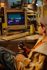 Person absorbed in playing classic video game on old school computer setup in cozy, cluttered room with nostalgic vibes