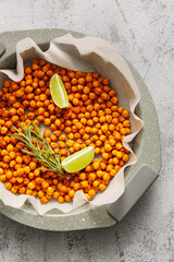 Baking dish with tasty fried chickpeas, lime and rosemary on grey background